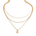 Triple-strand layered necklace with smooth oval pendant, close-up