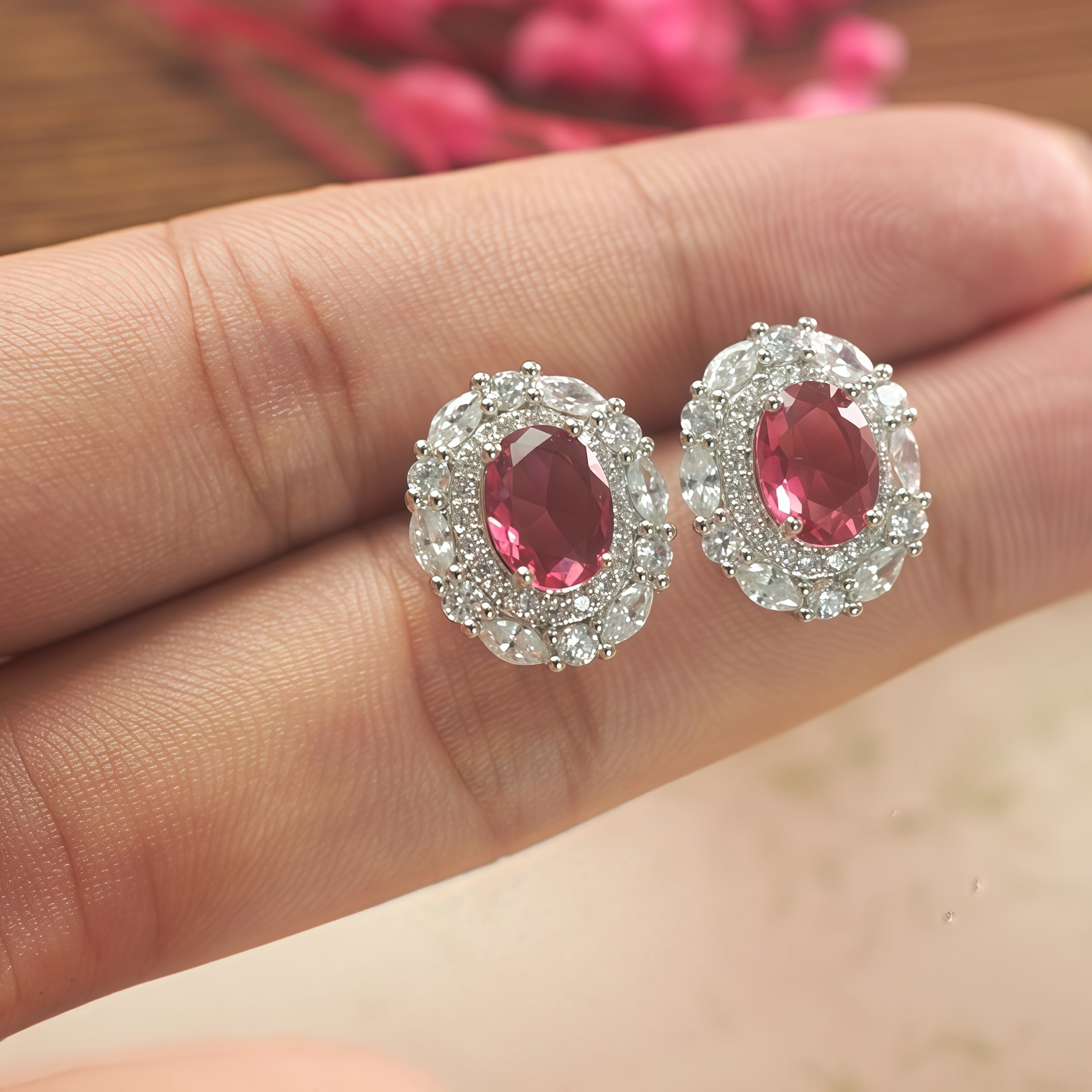 Woman wearing ruby-red CZ halo stud earrings, everyday jewelry