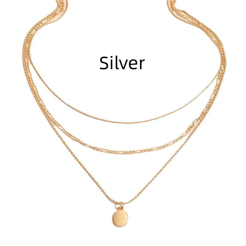 Layered gold-tone necklace with mixed chains worn on a woman