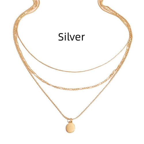 Layered gold-tone necklace with mixed chains worn on a woman